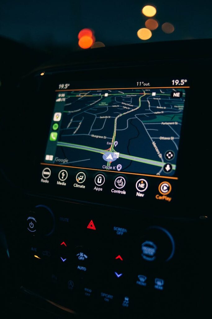 A car's GPS navigation screen showing a map interface illuminated during a night drive.