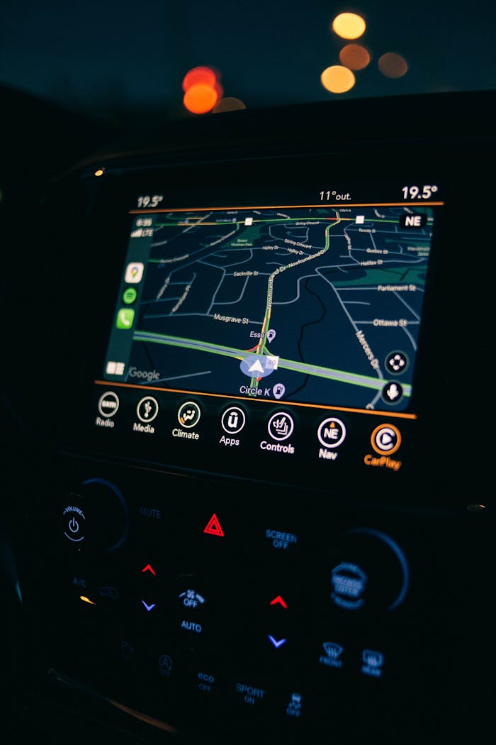 A car's GPS navigation screen showing a map interface illuminated during a night drive.